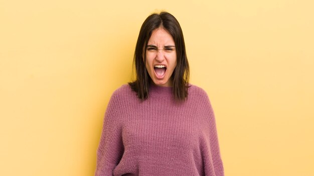 Młoda latynoska kobieta krzycząca agresywnie wyglądająca na bardzo rozgniewaną, sfrustrowaną, oburzoną lub zirytowaną, krzyczącą nie