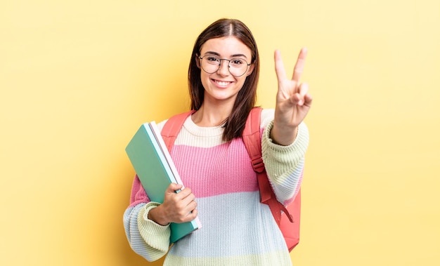 Młoda Latynoska Kobieta Uśmiechnięta I Wyglądająca Przyjaźnie, Pokazując Numer Dwa. Koncepcja Studenta