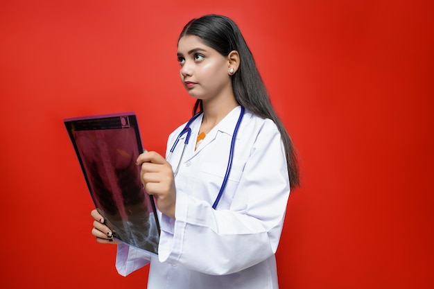 młoda lekarka trzymająca prześwietlenie w płaszczu i stetoskopie indyjski model pakistański