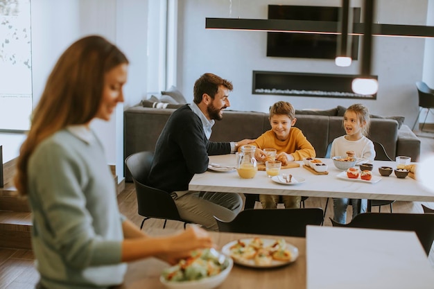 Młoda mama przygotowuje śniadanie dla swojej rodziny w nowoczesnej kuchni