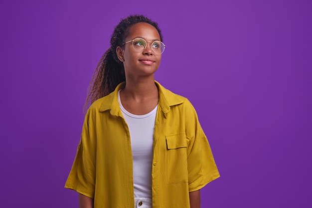 Młoda marzycielska Afroamerykanka w okularach myśli o szczęśliwej przyszłości