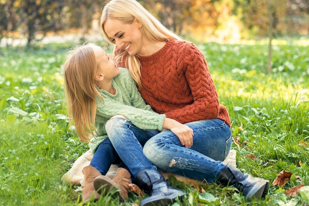 Młoda matka i córka przytulanie siebie na zewnątrz.