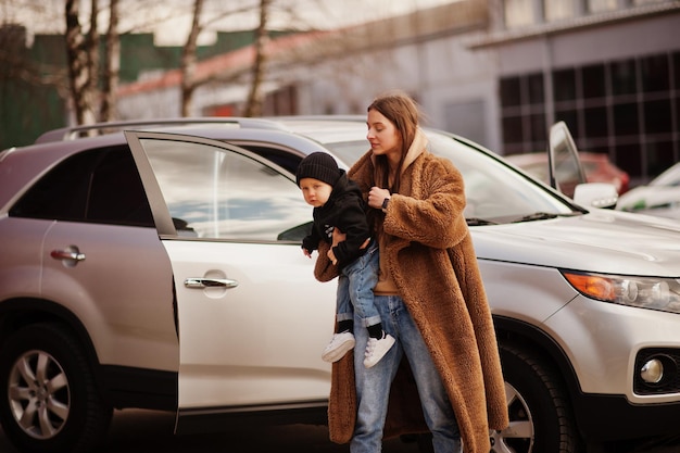 Młoda matka i dziecko stoją w pobliżu samochodu suv Koncepcja bezpieczeństwa jazdy