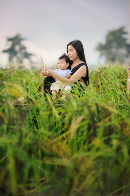 Zdjęcie młoda matka i słodkie dziecko relaksujące się na farmie przyrody w lecie