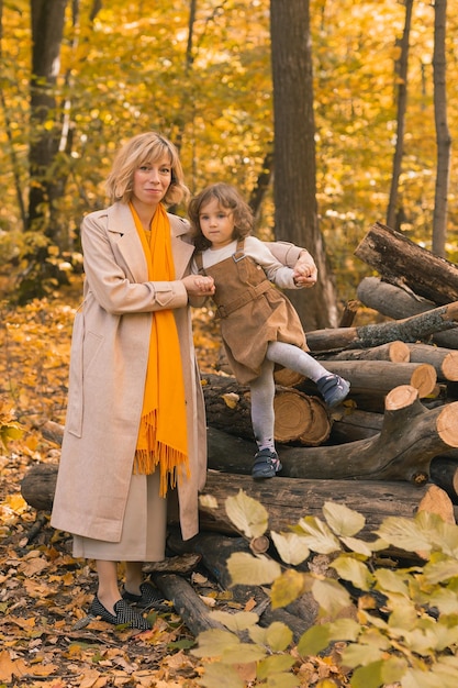 Młoda matka z córeczką w jesiennym parku. Sezon jesienny, koncepcja rodzicielstwa i dzieci.