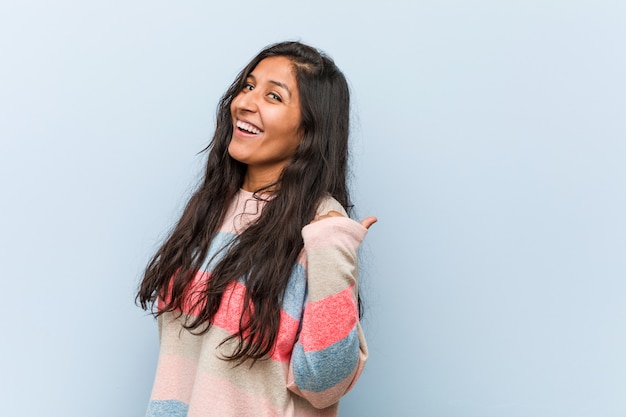 Młoda Moda Indyjska Kobieta Wskazuje Kciukiem Palec, śmiejąc Się I Beztrosko
