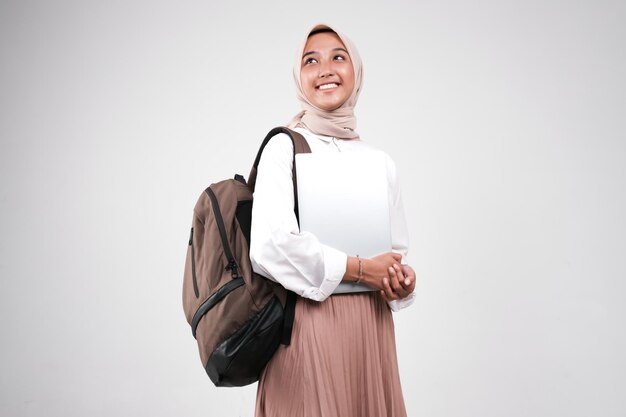 Zdjęcie młoda muzułmańska studentka niesie laptopa przygotuj się z powrotem do szkoły na białym tle