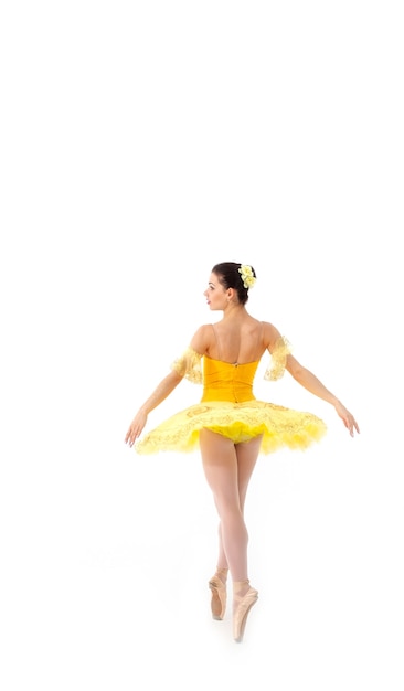 Młoda nowoczesna balerina z żółtą tutu robi pozę.
