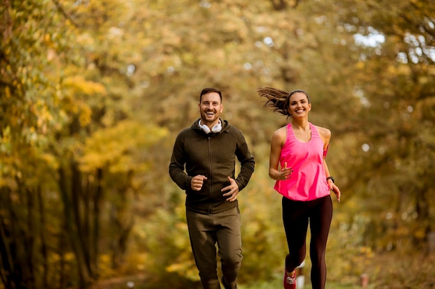 Młoda para biega razem w jesiennym parku