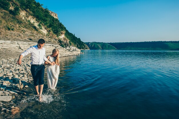 Młoda para chodzić na piaszczystej plaży