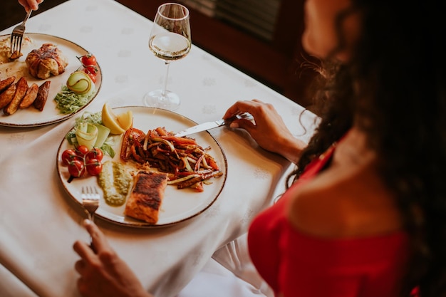 Młoda para jedząca obiad z białym winem w restauracji