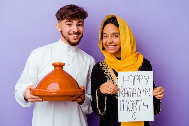 Młoda para marokańskich ubrana w typowy strój arabski świętuje Ramadan na fioletowym tle