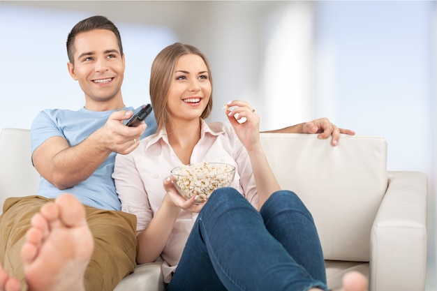 Młoda para ogląda telewizję w domu