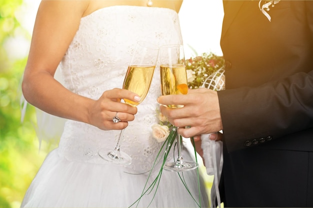 Młoda para ślubna panna młoda i pan młody trzyma kieliszki do szampana