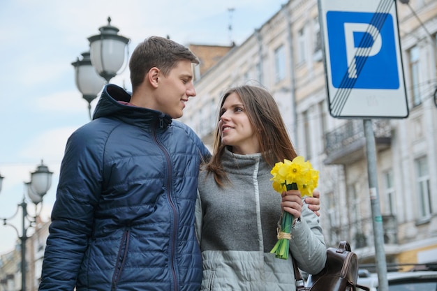 Młoda para spaceru z bukietem żółtych wiosennych kwiatów