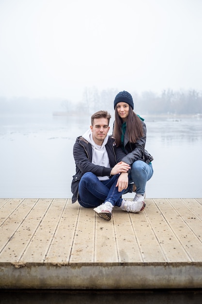 Młoda para spędza razem czas nad jeziorem Gebart w mglisty zimowy dzień w Zalaegerszeg na Węgrzech