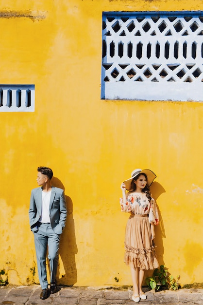 młoda para stoi przed pomarańczową ścianą w słońcu