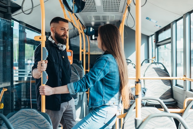 Zdjęcie młoda para stoi w jadącym autobusie podczas rozmowy