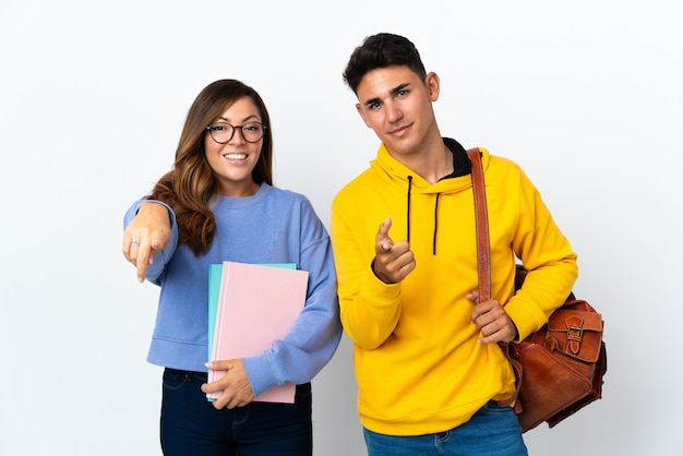 Młoda para studentów na białych punktach palcem na ciebie z pewnym siebie wyrazem