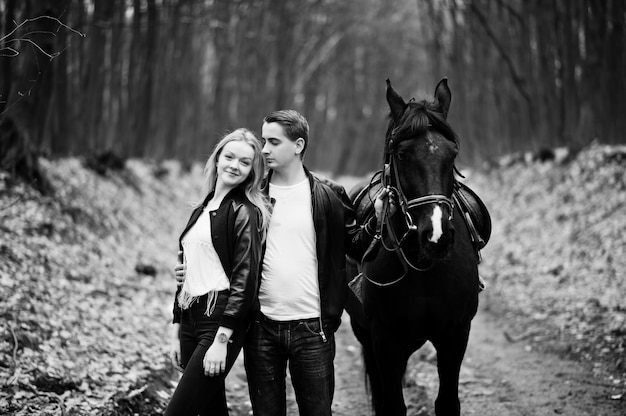 Młoda para stylowa w miłości w pobliżu konia w lesie jesienią