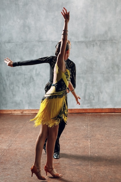 Zdjęcie młoda para tancerzy tańczy taniec towarzyski cha-cha-cha.