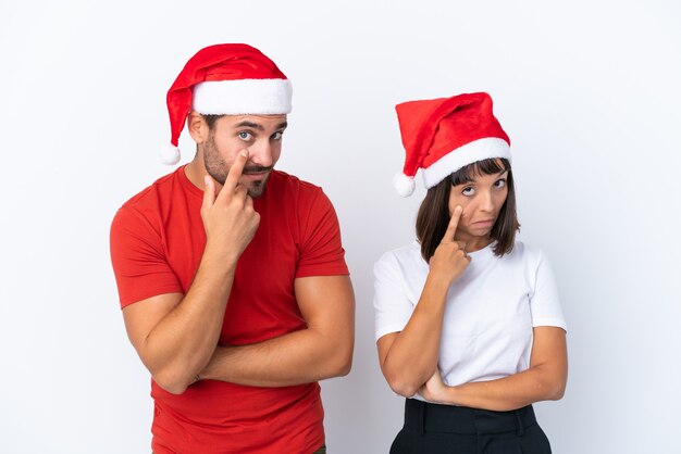 Młoda para w świątecznym kapeluszu na białym tle patrząc do przodu