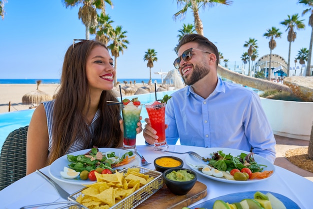 Młoda para z koktajli w restauracji przy basenie