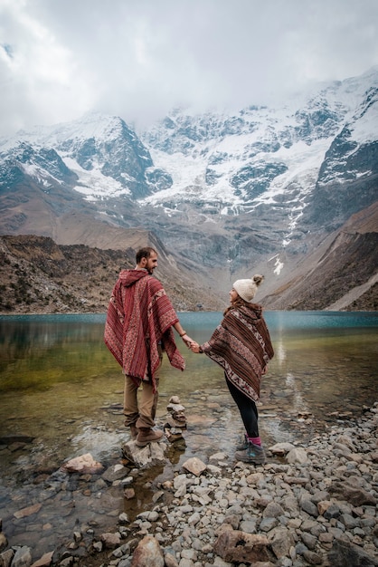 Młoda para z poncho na wakacjach w Laguna Humantay w Peru