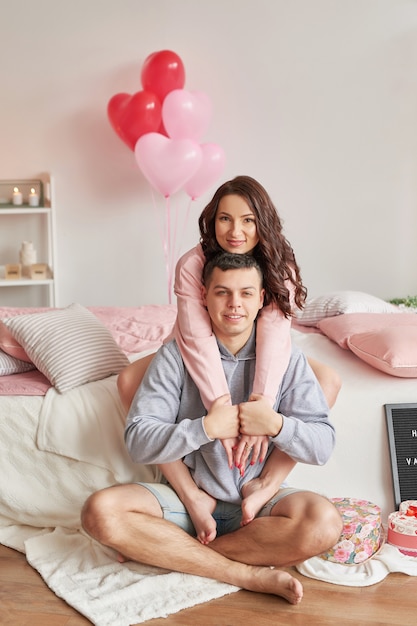Młoda para zakochanych w domu na łóżku z okazji Walentynek