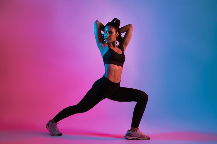 Zdjęcie młoda piękna azjatka w strojach sportowych robi rozciąganie przed treningiem w fitness