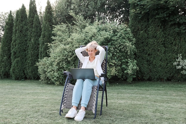Młoda piękna biznesowa kobieta pracuje na laptopie freelancer pracuje w naturze Businesswoman at Work Outdoors