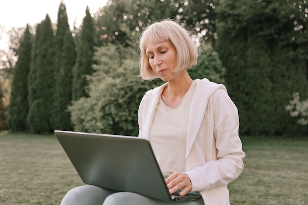 Młoda piękna biznesowa kobieta pracuje na laptopie freelancer pracuje w naturze Businesswoman at Work Outdoors