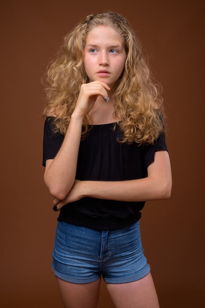 Młoda piękna blondynka nastolatka myśli na brązowo
