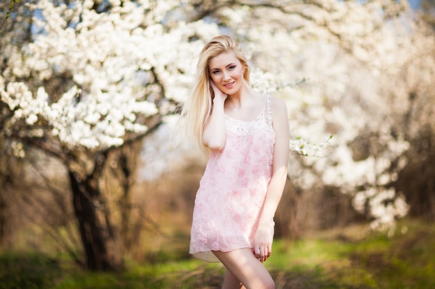 Młoda piękna blondynka uśmiechnięta kobieta w białej mini sukience