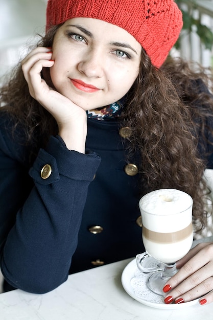 Młoda piękna brunetka w ulicznej kawiarni