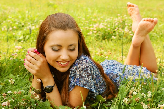 Młoda piękna dziewczyna kładzie się na trawie