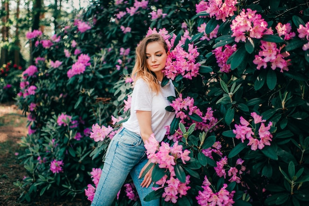 Młoda piękna dziewczyna pozuje wśród kwitnących drzew