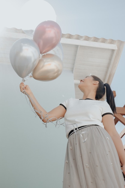 Młoda piękna dziewczyna uśmiecha się trzymając balony świętuje