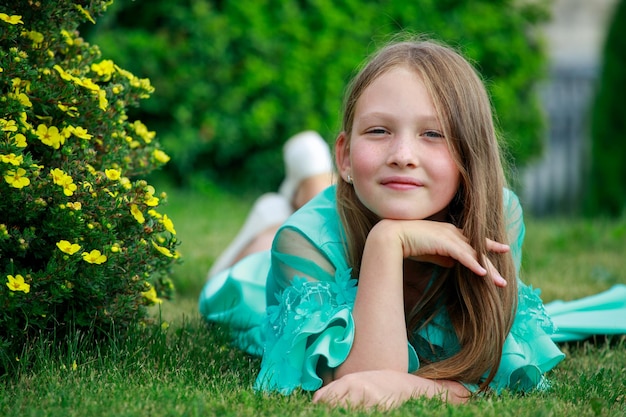 Młoda Piękna Dziewczyna W Niebieskiej Sukience Leży Na Trawie W Parku