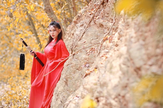 Młoda piękna kobieta azjatyckich sukienka w tradycyjnym chińskim starym stylu wojownika mody ze starożytnym słowem