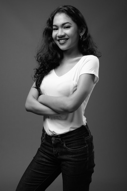 młoda piękna kobieta Azji przeciwko szarej ścianie w czerni i bieli