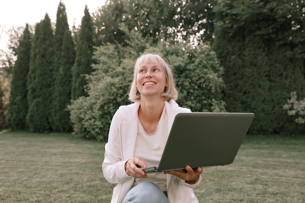 Młoda piękna kobieta biznesu pracująca na laptopie freelancer pracuje w naturze