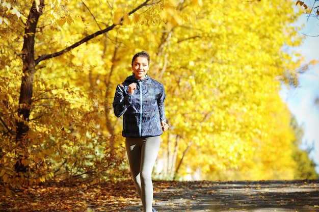 Młoda piękna kobieta jogging w jesiennym parku