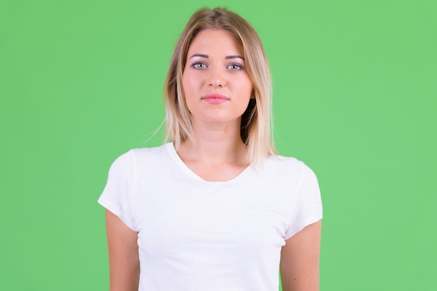 Zdjęcie młoda piękna kobieta o blond włosach przeciwko klucz chrominancji na zielono