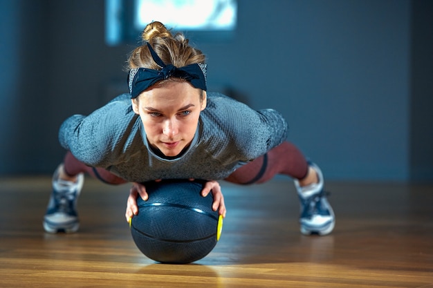 Młoda piękna kobieta robi rozciąganie w sportowej