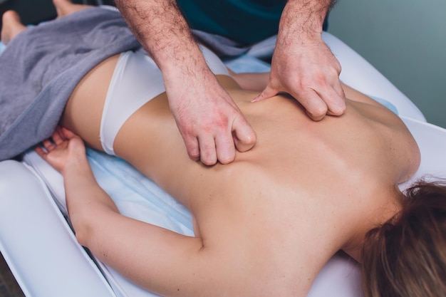 Młoda piękna kobieta robiąca masaż w salonie spa, fizjoterapeutka.