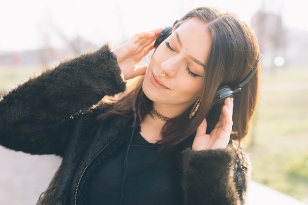 Zdjęcie młoda piękna kobieta słucha muzyka z hełmofonami