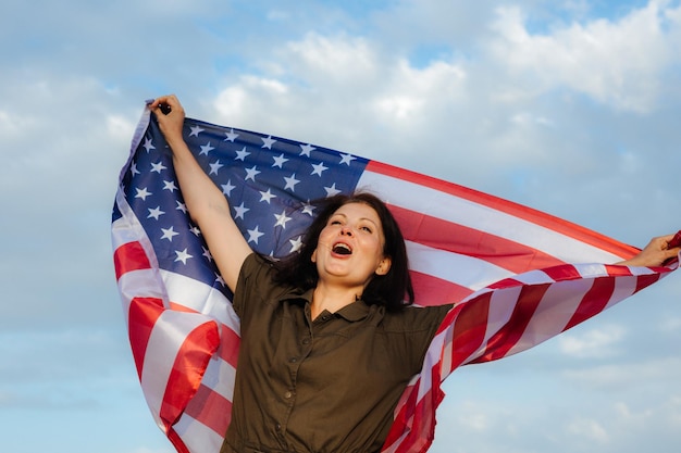 Młoda piękna kobieta trzyma flagę USA