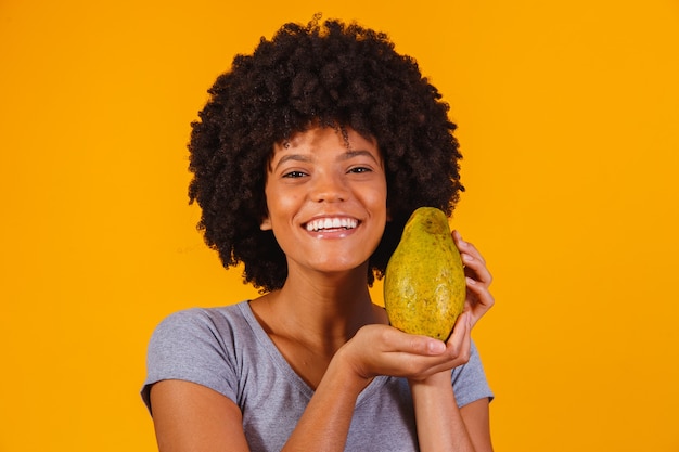 Młoda piękna kobieta trzyma papaję na żółto