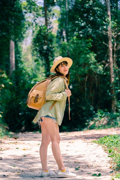 Młoda piękna kobieta w jesiennej modzie ze skórzanym plecakiem podróżującym w naturze Tajlandii z jesiennymi liśćmi